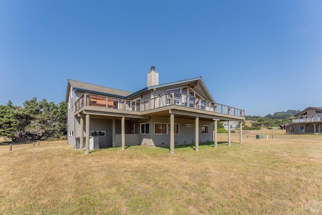 rear view of house with a wooden deck and a lawn