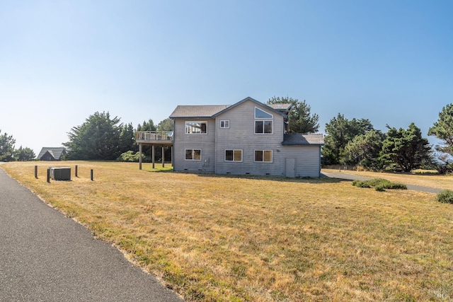 view of front facade with a deck and a front lawn