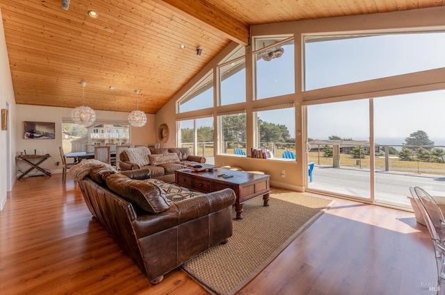 living room featuring beamed ceiling, high vaulted ceiling, a wealth of natural light, and a notable chandelier