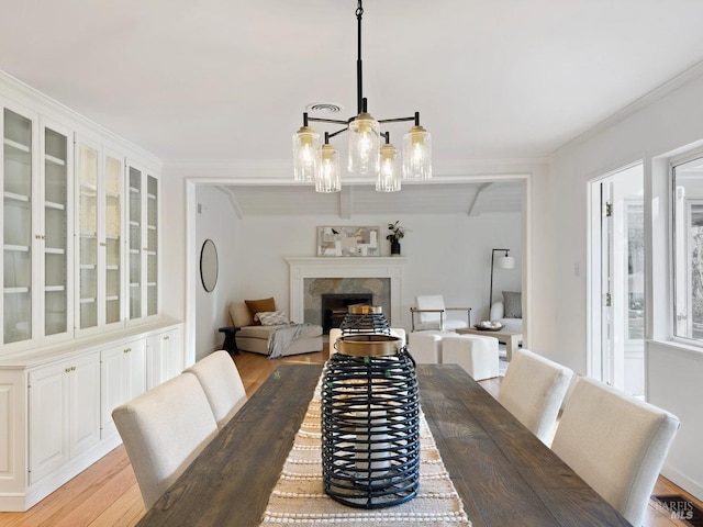 dining room with crown molding and light wood-type flooring