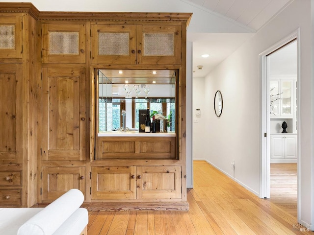 interior space featuring lofted ceiling and light hardwood / wood-style floors