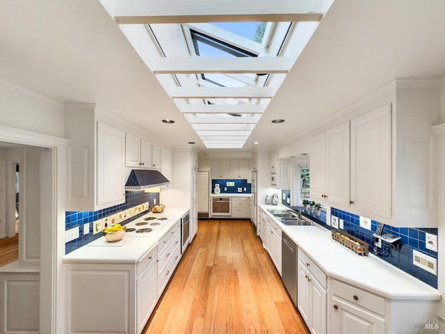 kitchen featuring white cabinetry, wall oven, extractor fan, stainless steel dishwasher, and light wood-type flooring