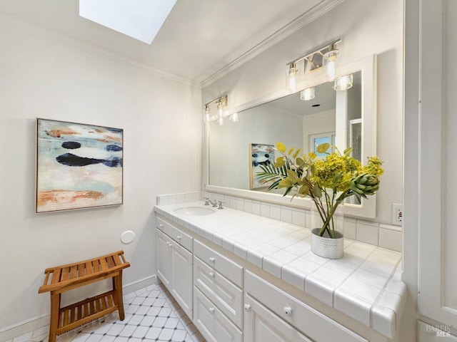 bathroom with vanity, tile patterned flooring, a skylight, and ornamental molding