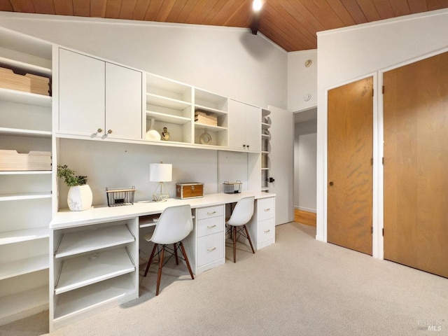 carpeted office space featuring lofted ceiling, built in desk, and wooden ceiling