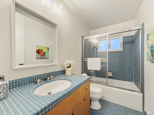 full bathroom with enclosed tub / shower combo, vanity, tile patterned floors, and toilet