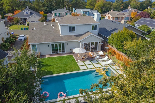 back of property featuring a fenced in pool, a patio area, an outdoor living space, and a yard