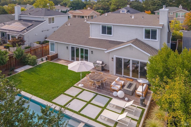 back of property with a patio, a fire pit, and a lawn