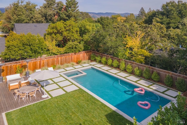 view of pool with a lawn, an in ground hot tub, and a deck