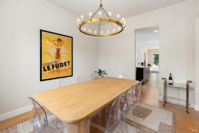 dining area featuring light hardwood / wood-style flooring and a chandelier