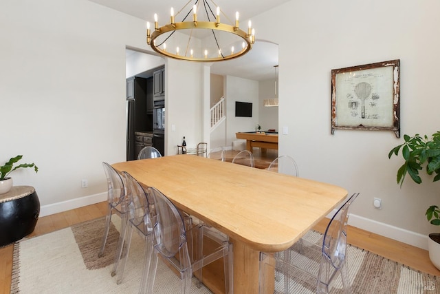 dining room featuring an inviting chandelier and light hardwood / wood-style flooring