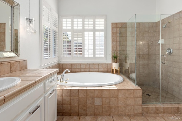 bathroom featuring plus walk in shower, vanity, and tile patterned floors