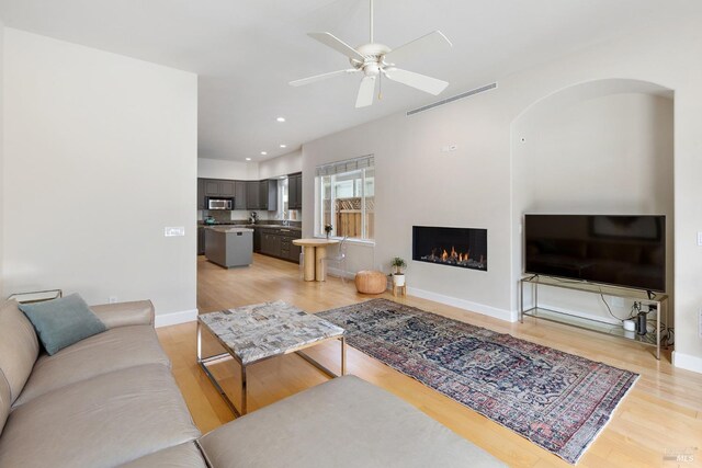 living room with light hardwood / wood-style floors and ceiling fan