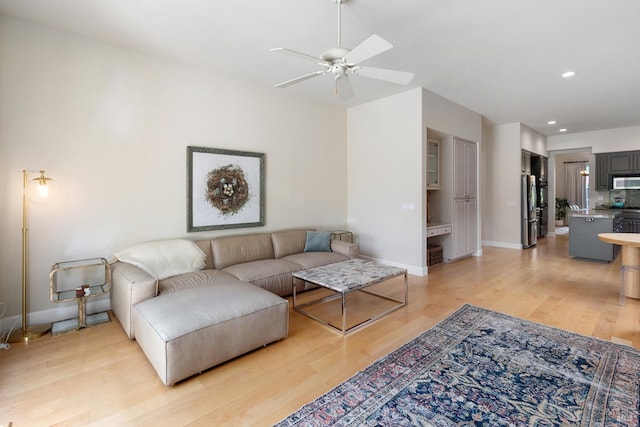 living room featuring ceiling fan and light hardwood / wood-style flooring