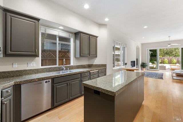 kitchen featuring a center island, sink, stainless steel dishwasher, ceiling fan, and light hardwood / wood-style floors