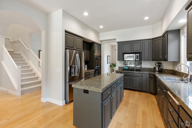 kitchen featuring a center island, sink, gray cabinets, appliances with stainless steel finishes, and light hardwood / wood-style floors