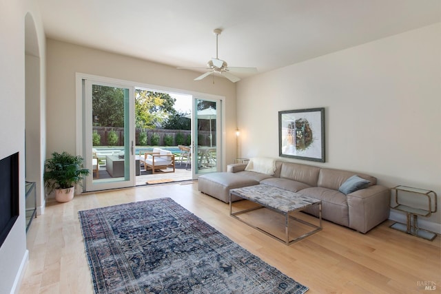 living room with light wood-type flooring and ceiling fan