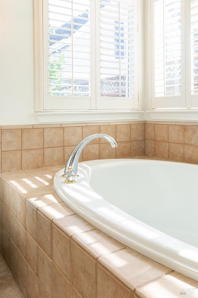 bathroom with a relaxing tiled tub