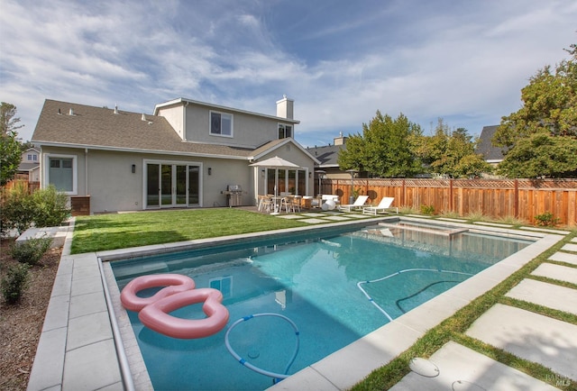 view of pool with a yard, a patio, and grilling area