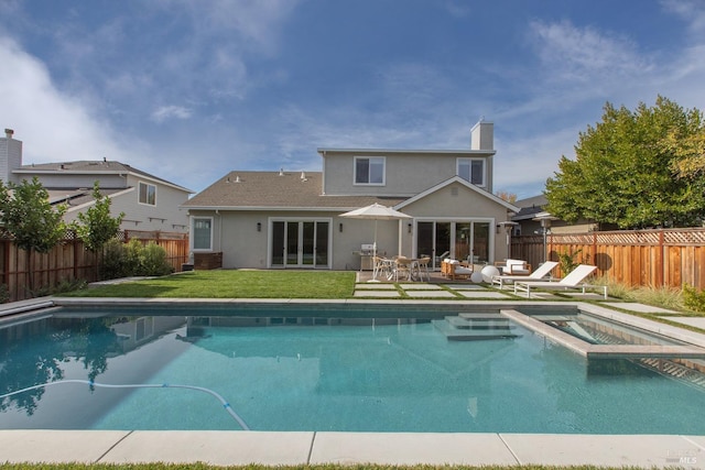 view of swimming pool with a patio area, a yard, and an in ground hot tub