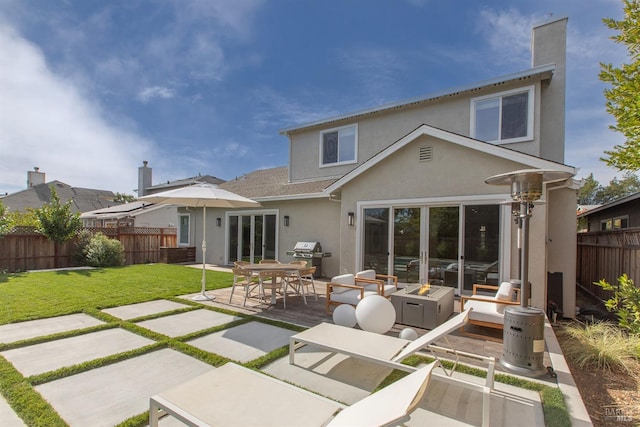 rear view of property featuring a lawn and a patio area