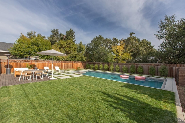 view of swimming pool with a lawn and a wooden deck