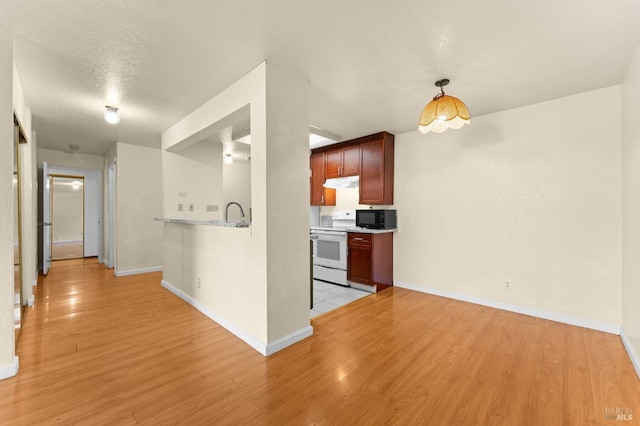 kitchen featuring electric stove, light stone countertops, light hardwood / wood-style floors, and a textured ceiling