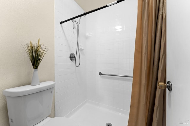 bathroom with a shower with curtain and toilet