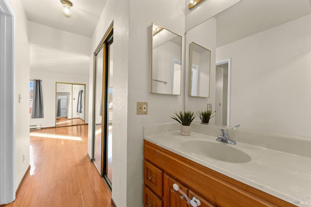 bathroom featuring a baseboard radiator, vanity, and hardwood / wood-style floors