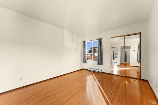 spare room with wood-type flooring and baseboard heating