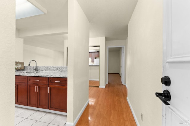 interior space with light stone counters, sink, and light tile patterned floors