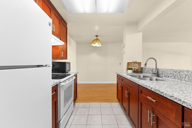 kitchen with pendant lighting, sink, white appliances, and light stone countertops