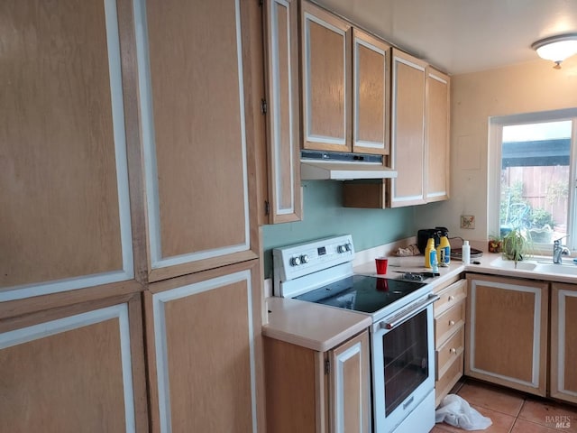 kitchen with light brown cabinetry, sink, light tile patterned floors, and white electric range oven