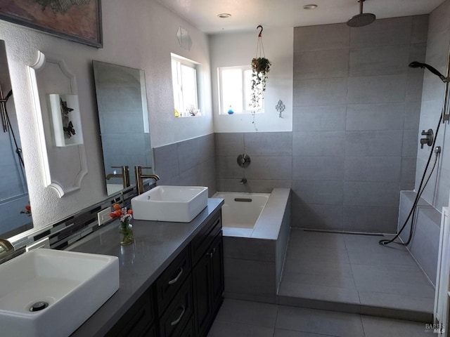 bathroom featuring tile patterned flooring, vanity, separate shower and tub, and tile walls