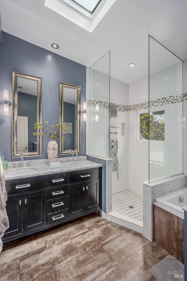 bathroom with plus walk in shower, vanity, and a skylight