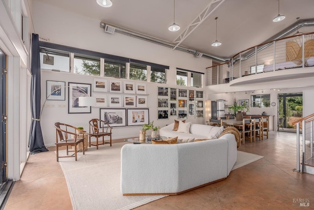 living room featuring concrete flooring and a high ceiling