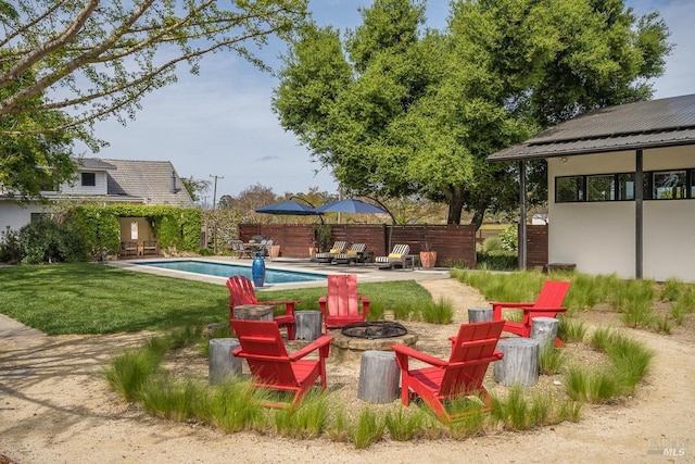 view of yard with a fenced in pool, a patio area, and an outdoor fire pit
