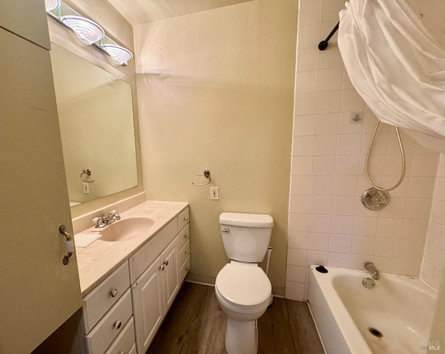 bathroom with toilet, wood finished floors, vanity, bathing tub / shower combination, and baseboards