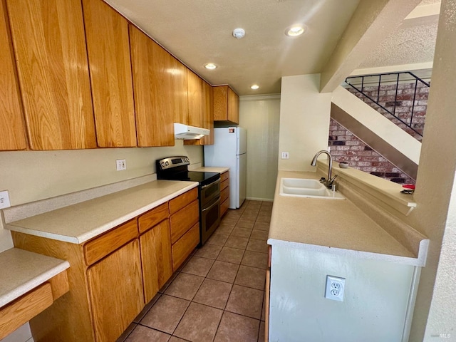 kitchen with tile patterned flooring, light countertops, under cabinet range hood, double oven range, and a sink