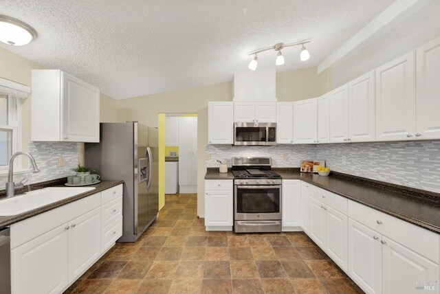 kitchen featuring stainless steel appliances, white cabinetry, tasteful backsplash, and sink