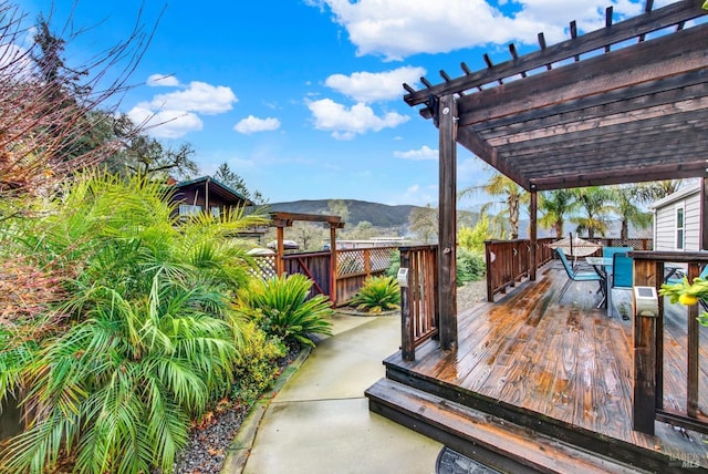 wooden terrace with a pergola and a mountain view