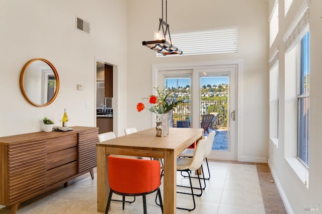 tiled dining area with a towering ceiling