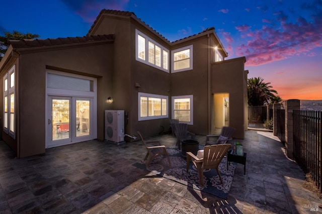 back house at dusk featuring a patio area