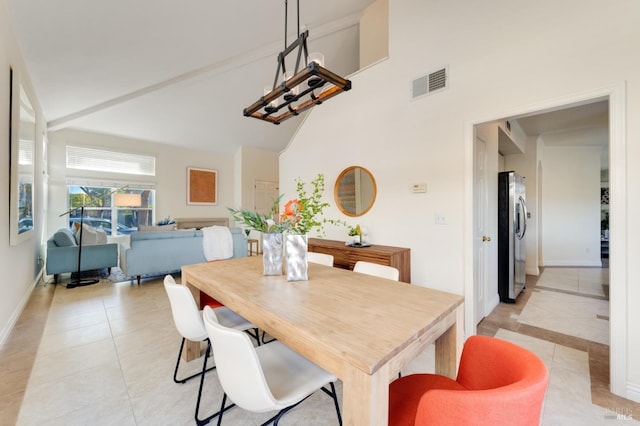 tiled dining area featuring vaulted ceiling