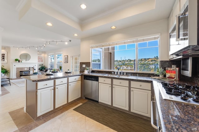 kitchen featuring sink, a raised ceiling, stainless steel dishwasher, kitchen peninsula, and light tile patterned floors