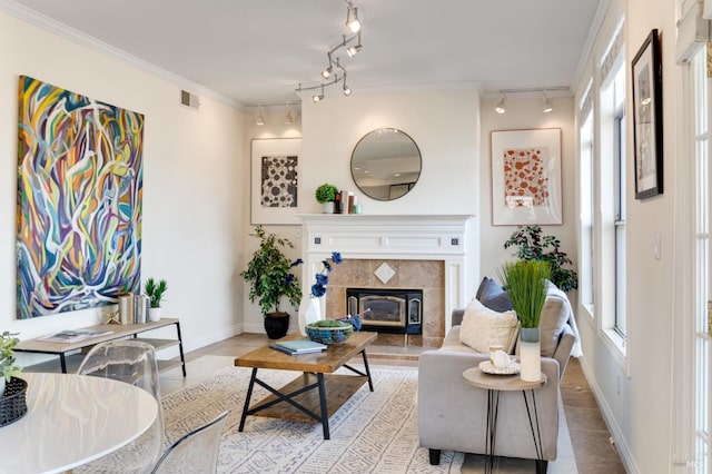 tiled living room featuring a tile fireplace, rail lighting, and ornamental molding