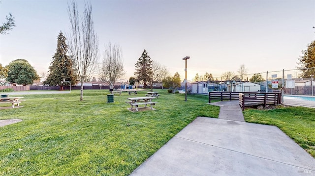 view of community with a lawn and fence