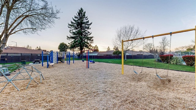 view of home's community featuring playground community, a lawn, and fence