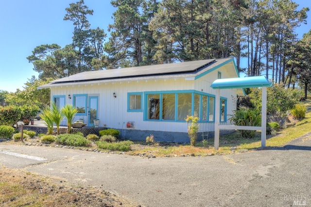 view of side of property featuring solar panels and french doors