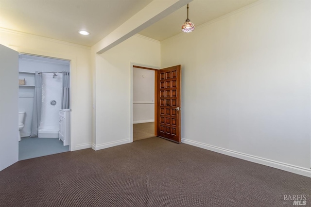 unfurnished bedroom with dark colored carpet and ornamental molding