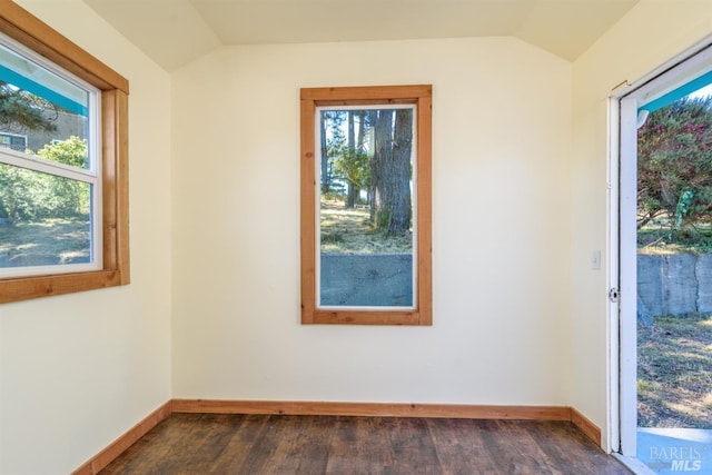 unfurnished room with dark wood-type flooring and lofted ceiling